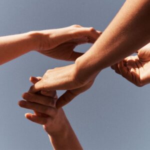 Hands holding each other to represent all parts of self working in alignment with Internal Family Systems